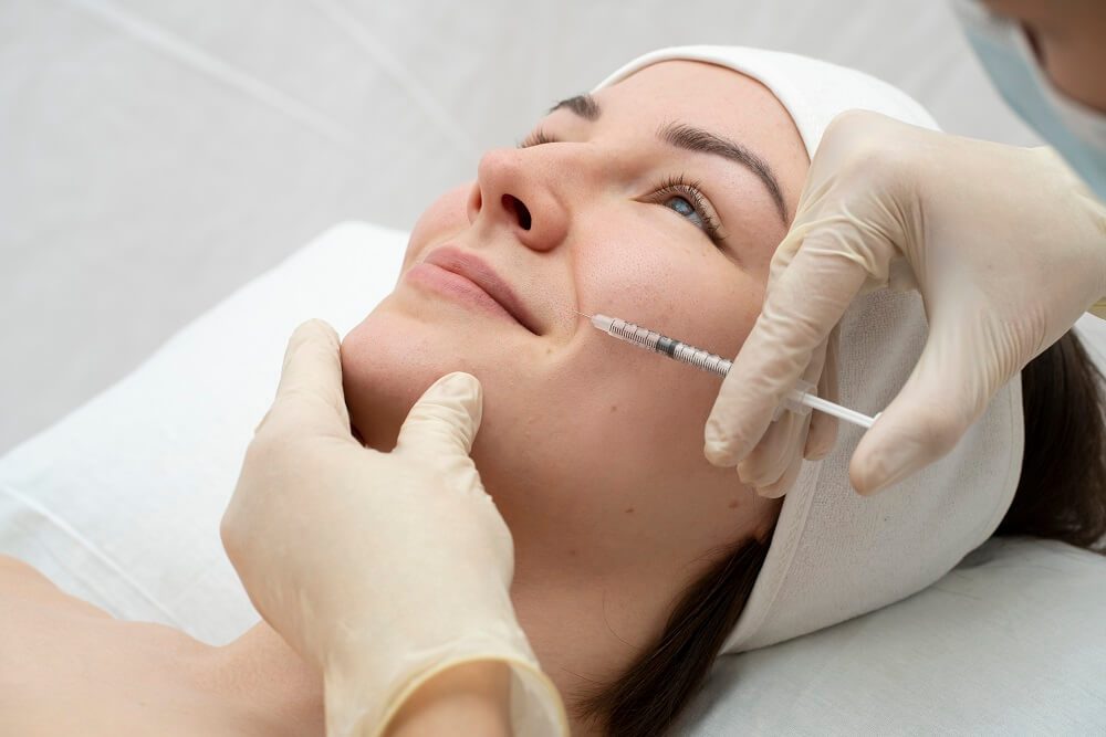 A woman getting her face waxed by an esthetician.