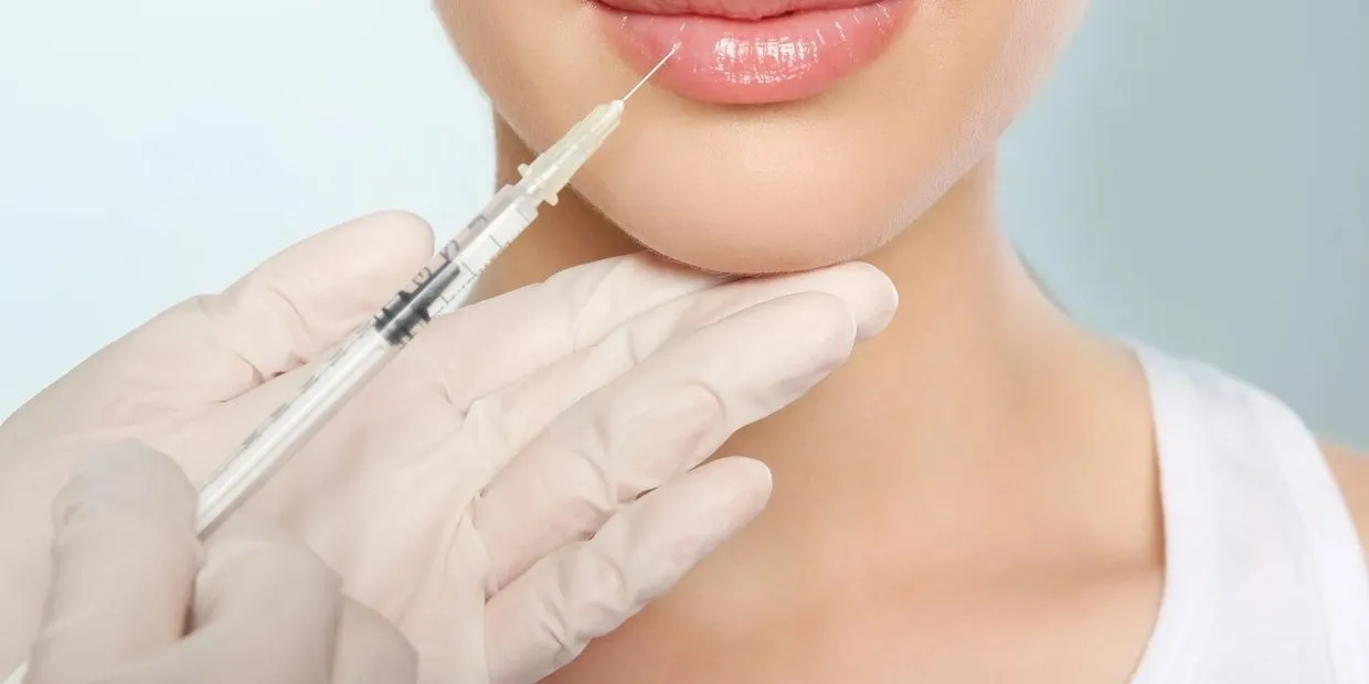 Woman receiving beauty injection in lips