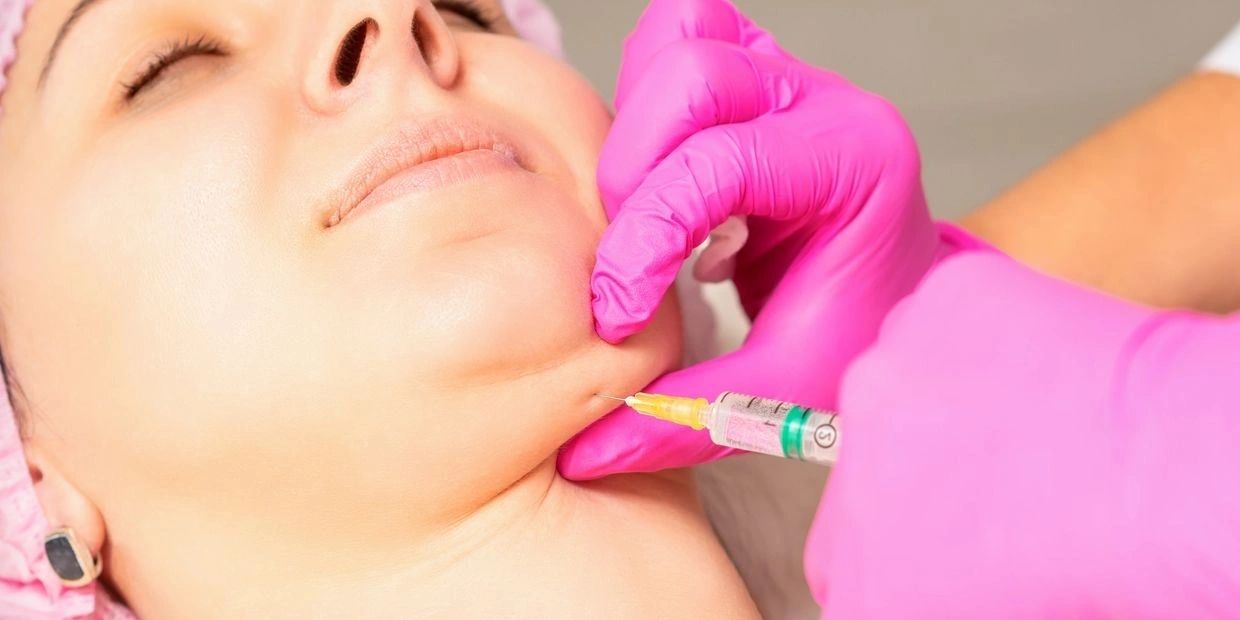 A woman getting an injection into her neck.