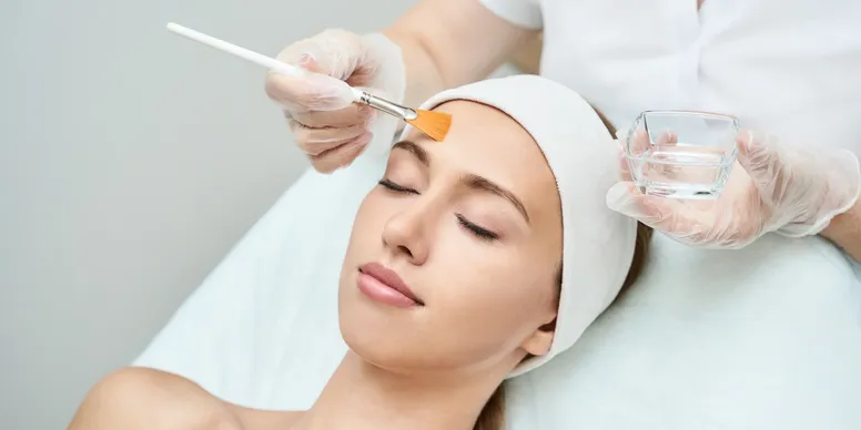 A woman getting her face waxed at the spa