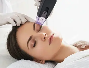 Woman receiving radiofrequency lifting procedure around eyes for her face skin rejuvenation at aesthetic cosmetology center