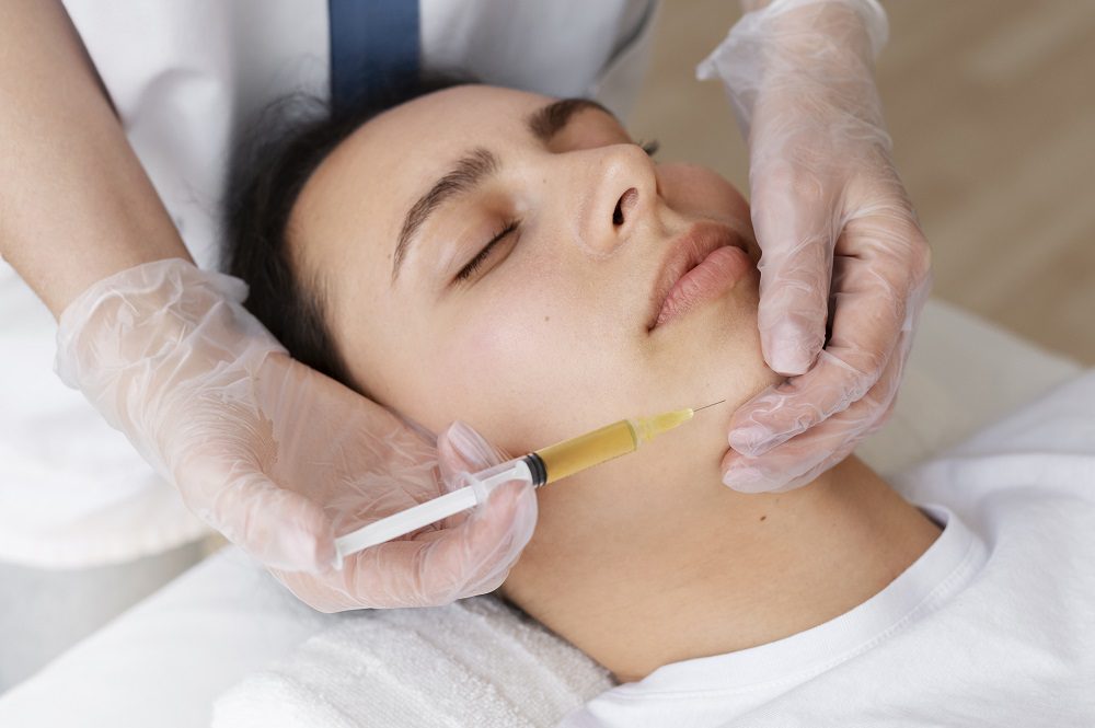 A woman getting her face waxed by a doctor.