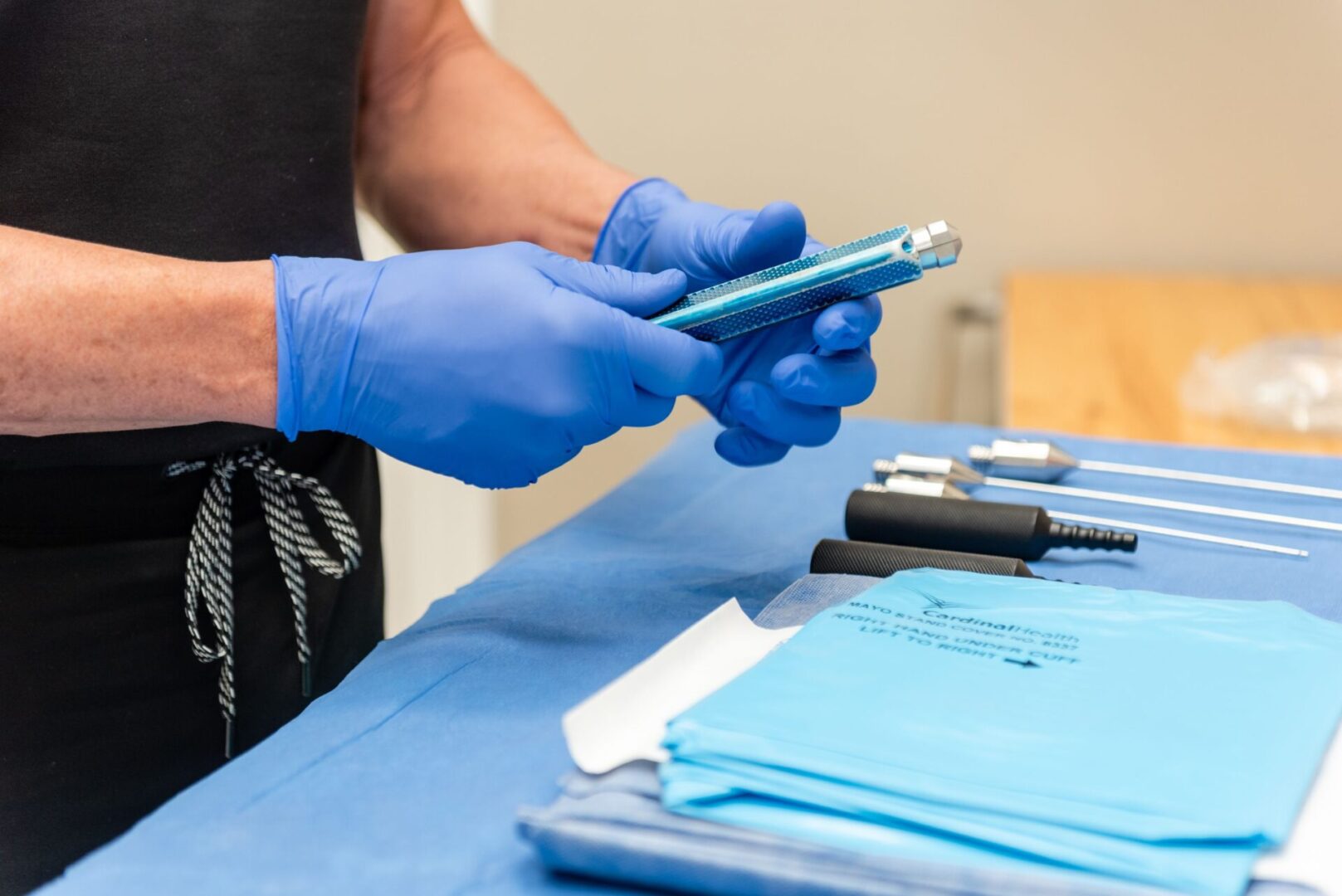 A person in blue gloves holding a phone.